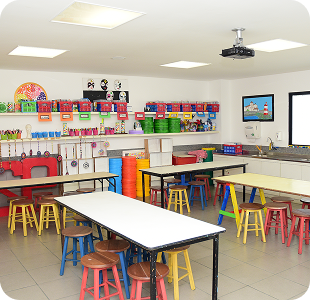 Sala de aula com prateleiras cheias de materiais coloridos
