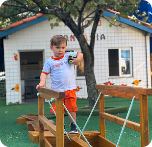 Menino brincando em playground de madeira
