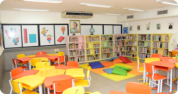 Biblioteca colorida e cantinho de leitura do Colégio São Paulo, com estantes de livros e mesinhas