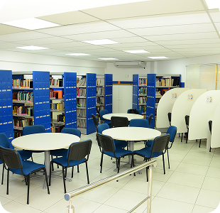 Biblioteca com estantes azuis e mesas redondas