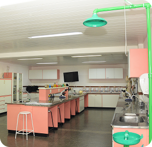 Laboratório de ciências com bancada rosa e pia verde